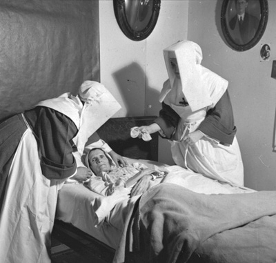 Reproduction d'une photographie de deux Filles de la Sagesse visitant des malades &agrave; domicile &agrave; Lavigne, Ontario, 1949.