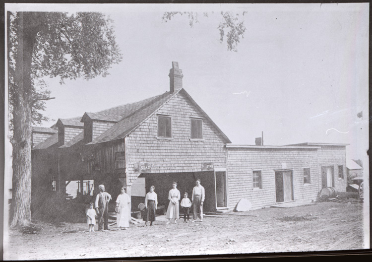 Reproduction d’une photographie du moulin &agrave; scie et de l’atelier &agrave; bois de construction, avec Godfroy Paiement, Caroline Paiement, Annette Paiement, Antonine L’Esp&eacute;rance, &Eacute;douard L’Esp&eacute;rance, Glen Sandfield (Ontario), ca 1911.
