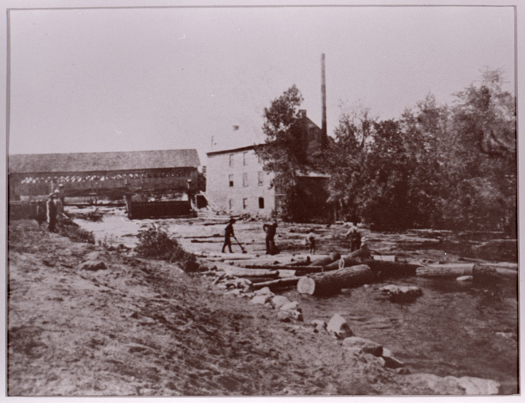 Reproduction d’une photographie du pont couvert, du moulin &agrave; scie et de draveurs, Martintown (Ontario), 1906.