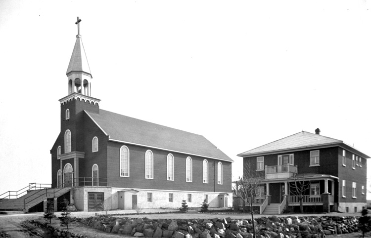 Reproduction d’une photographie de l’&eacute;glise et du presbyt&egrave;re de L’Assomption de Kirland Lake (Ontario), ca 1947.