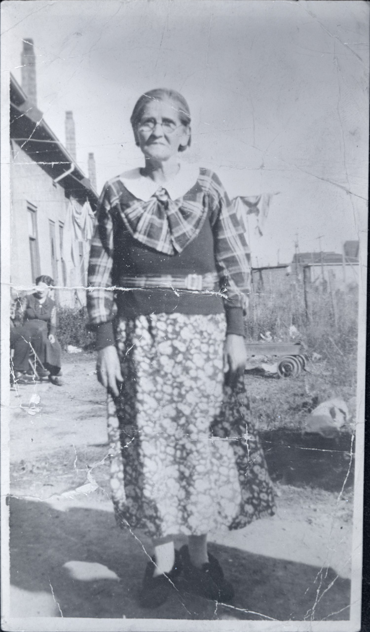 Reproduction d’une photographie de Marie Fortin, &eacute;pouse de Alphonse Marois, dans sa cour, Welland (Ontario), avant 1936.